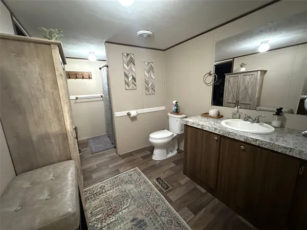 a bathroom with a granite countertop sink toilet and shower