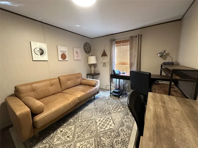 a living room with furniture wooden floor and a window