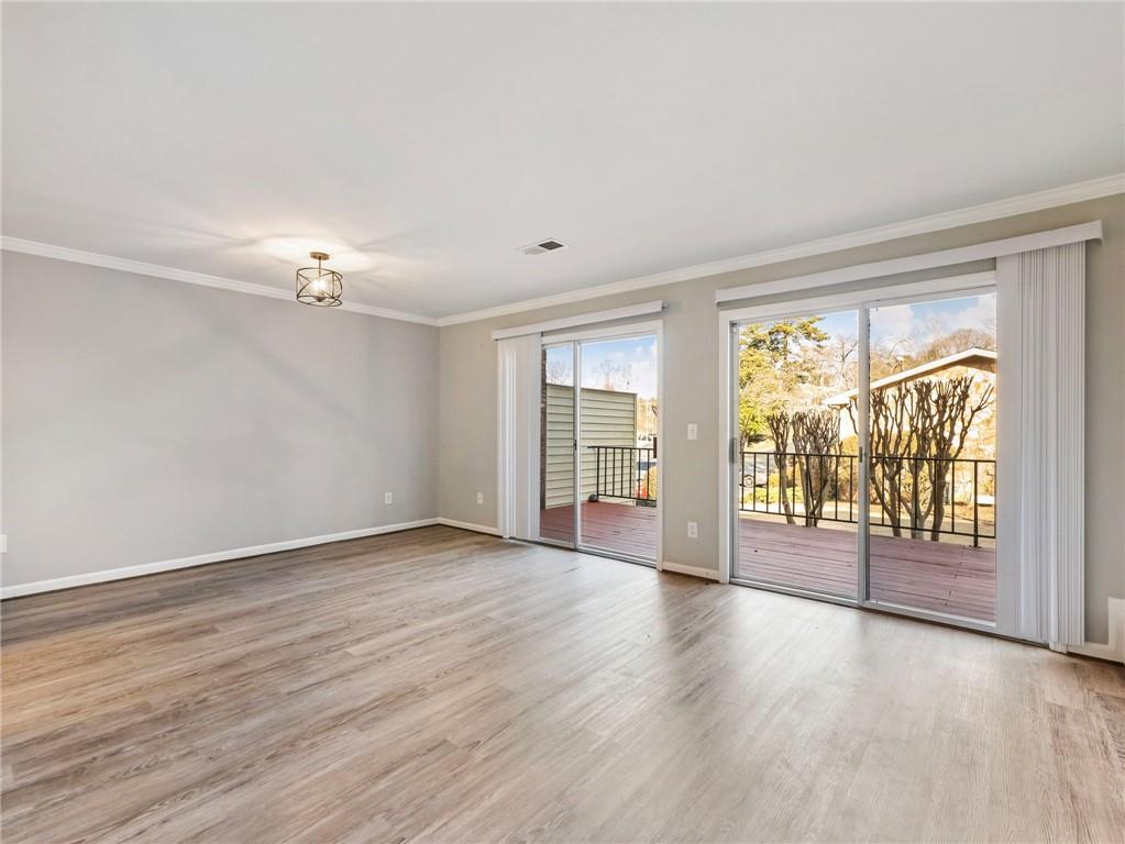 6500 Gaines Ferry Road, Unit A2 Flowery Branch, GA 30542 - Photo 13 of 42 a view of an empty room with wooden floor and a window