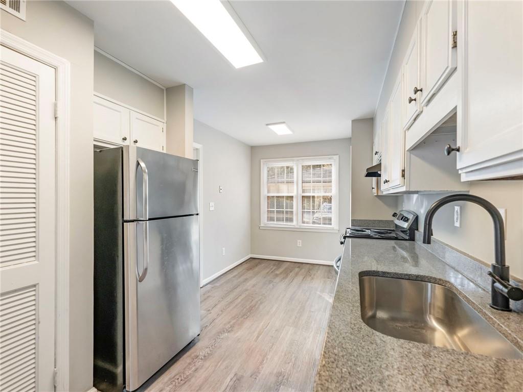 6500 Gaines Ferry Road, Unit A2 Flowery Branch, GA 30542 - Photo 16 of 42 a kitchen with a refrigerator sink and cabinets