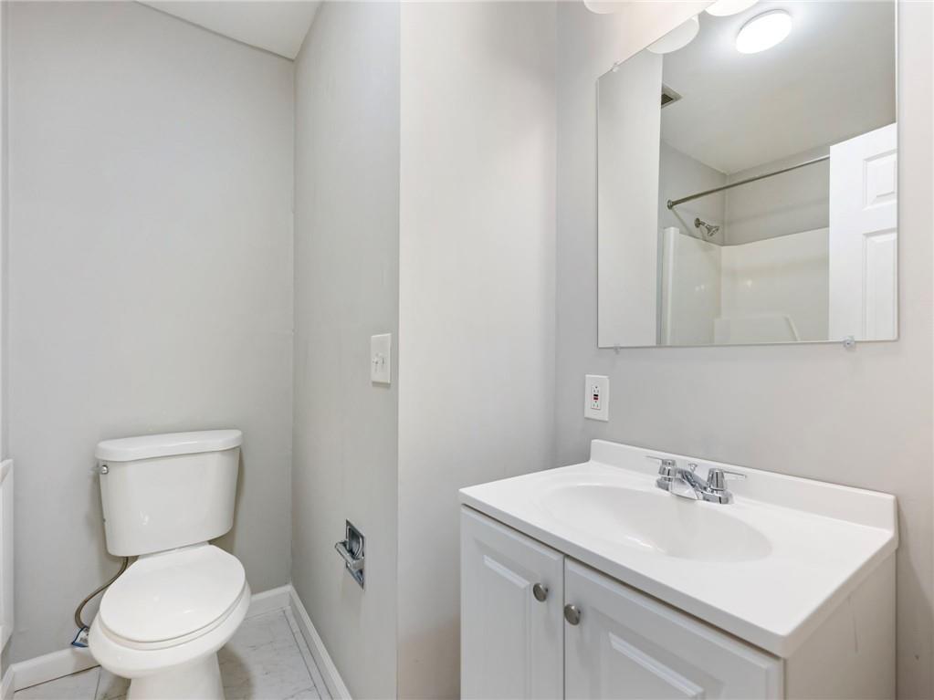 6500 Gaines Ferry Road, Unit A2 Flowery Branch, GA 30542 - Photo 25 of 42 a bathroom with a sink a toilet and a mirror