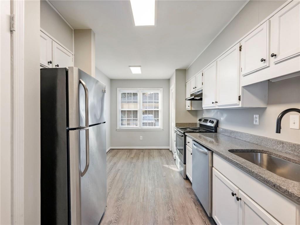 6500 Gaines Ferry Road, Unit A2 Flowery Branch, GA 30542 - Photo 4 of 42 a kitchen with stainless steel appliances a refrigerator a sink a stove a refrigerator and white cabinets