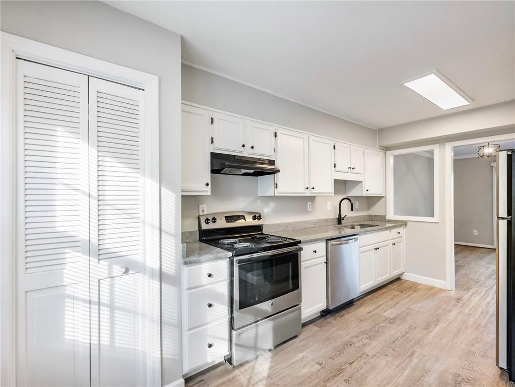 6500 Gaines Ferry Road, Unit A2 Flowery Branch, GA 30542 - Photo 6 of 42 a kitchen with stainless steel appliances granite countertop a stove a sink and white cabinets