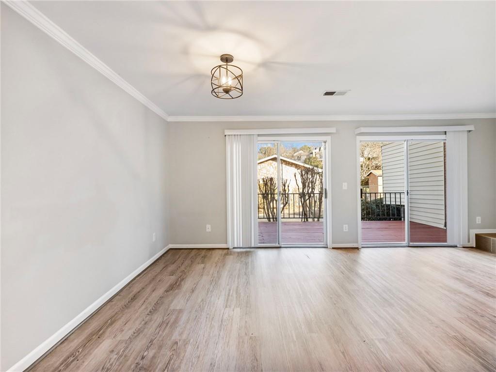 6500 Gaines Ferry Road, Unit A2 Flowery Branch, GA 30542 - Photo 10 of 42 a view of an empty room with wooden floor and a window