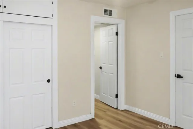 a view of a hallway with wooden floor