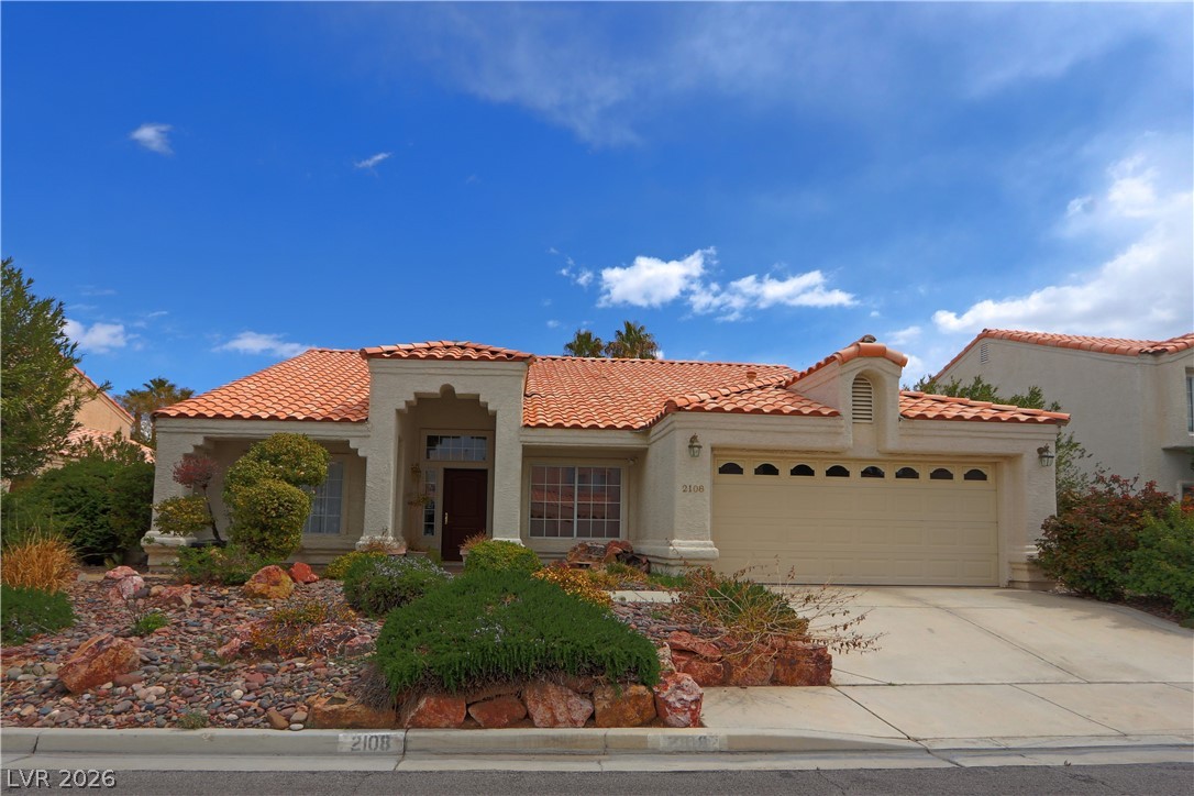 2108 Crestpoint Way Las Vegas, NV 89134 - Photo 2 of 27 A charming single-story residence boasts a terracotta tile roof and mature desert landscaping.