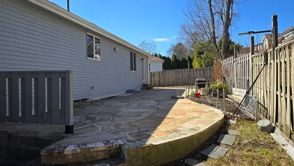 a view of a backyard with wooden fence