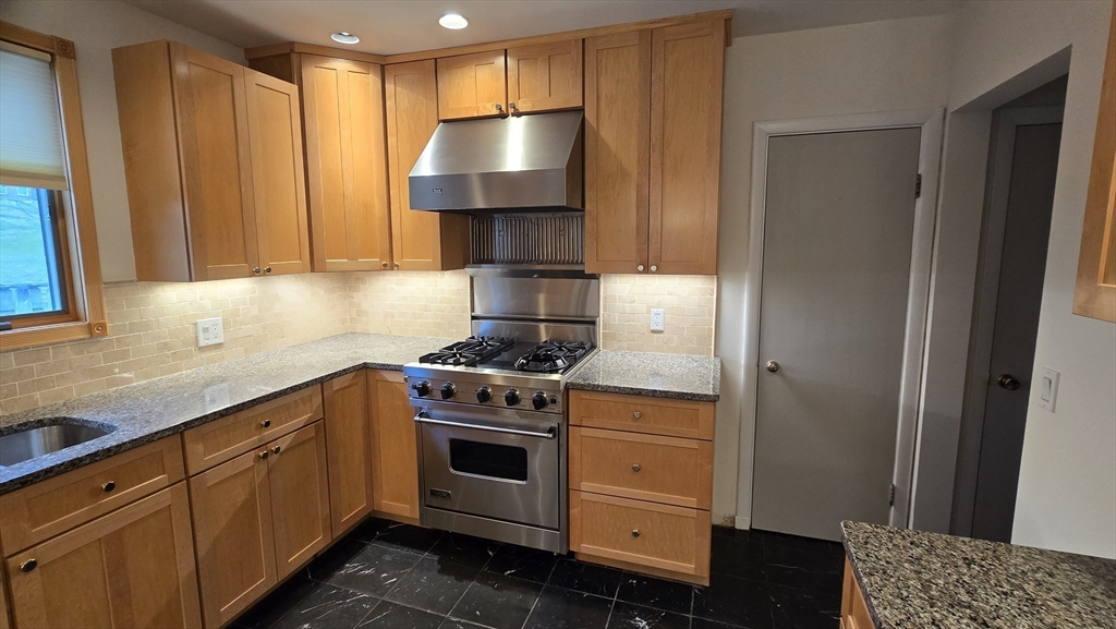 91 Mary Ellen Road Newton, MA 02468 - Photo 9 of 32 a kitchen with stainless steel appliances a stove a refrigerator and cabinets