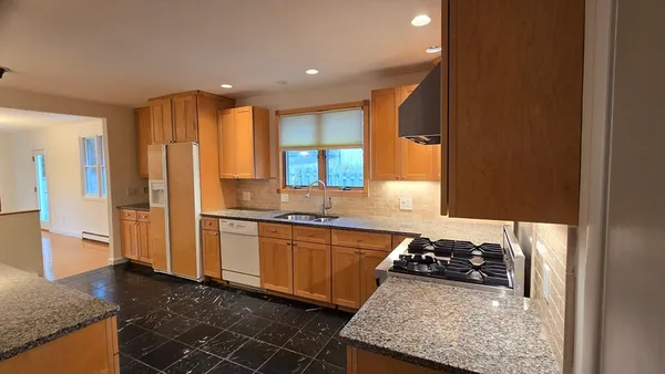 a kitchen with stainless steel appliances granite countertop a sink stove and refrigerator