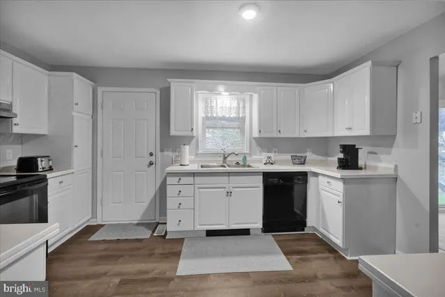 a kitchen with granite countertop white cabinets and white appliances