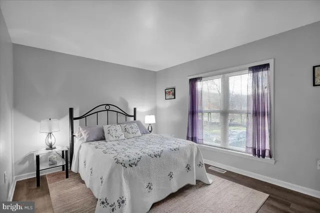 a bedroom with a large bed and a window with lamp