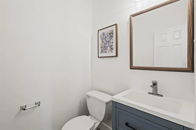 a bathroom with a toilet a sink and mirror