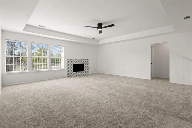 an empty room with fireplace and windows