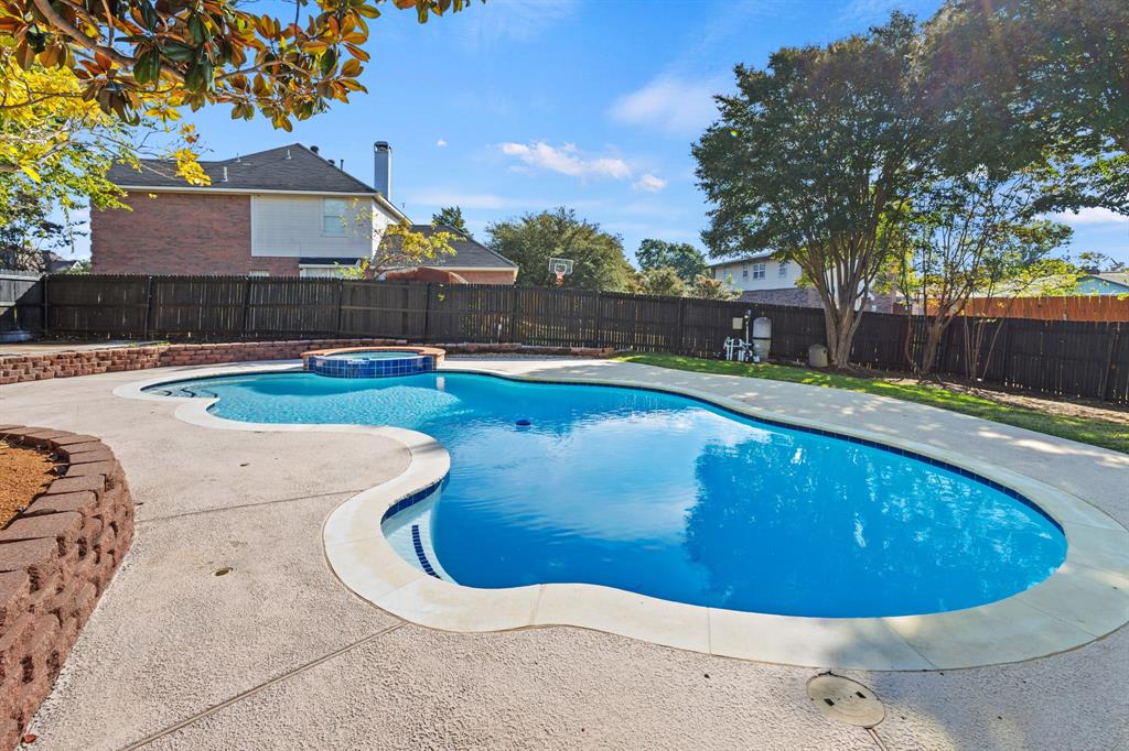 9502 Heartstone Lane Rowlett, TX 75087 - Photo 21 of 22 a view of a swimming pool with a yard and a fountain
