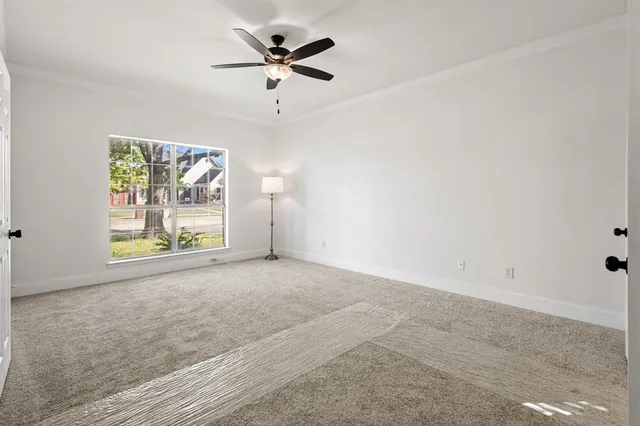 an empty room with windows and a ceiling fan