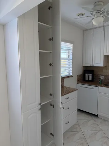 a kitchen with white cabinets and white appliances