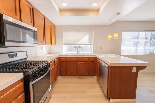 a kitchen with stainless steel appliances granite countertop a sink stove and cabinets