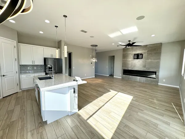 a large kitchen with stainless steel appliances a large counter top and a wooden floors