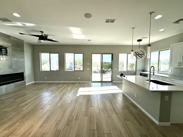 a large kitchen with stainless steel appliances kitchen island granite countertop a stove a sink a refrigerator and blue cabinets with wooden floor