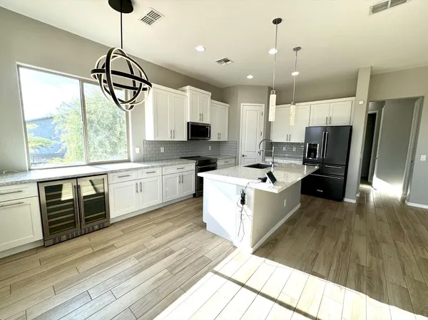 a kitchen with stainless steel appliances wooden floor and a refrigerator