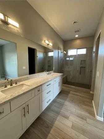 a bathroom with a double vanity sink toilet and shower