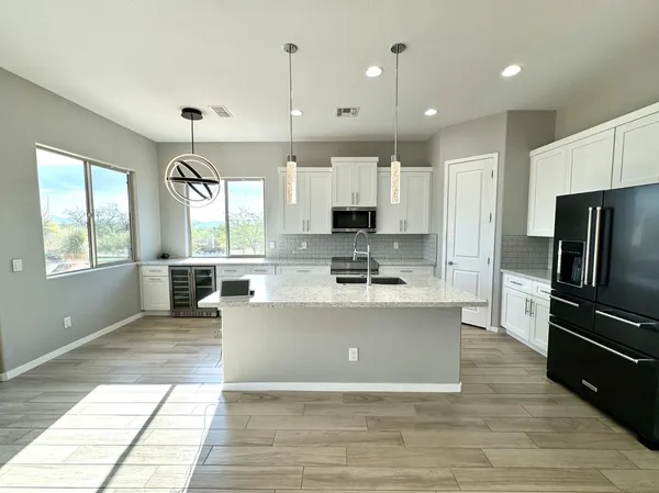 a large kitchen with kitchen island a large counter top stainless steel appliances and cabinets