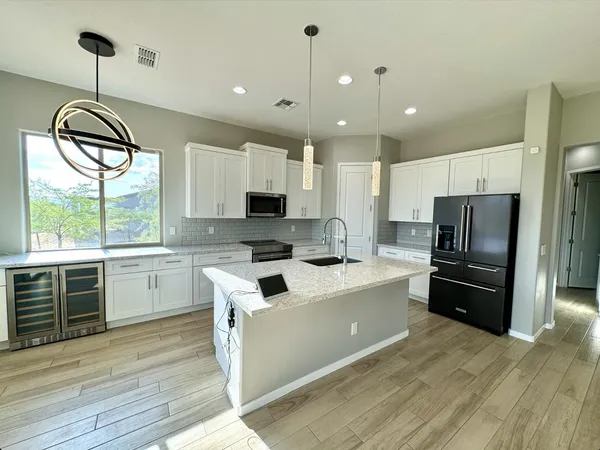 a kitchen with kitchen island granite countertop a sink appliances cabinets and wooden floor
