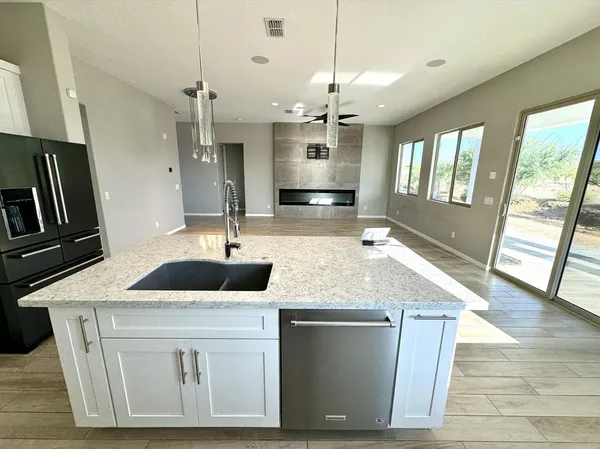 a kitchen with stainless steel appliances granite countertop a sink a oven a refrigerator a counter space and wooden floor
