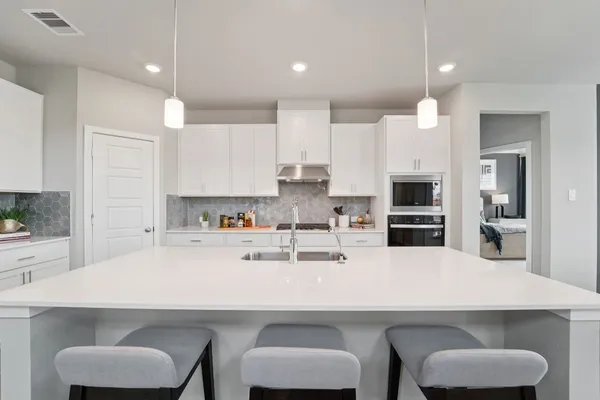 a kitchen with stainless steel appliances a sink a table and chairs