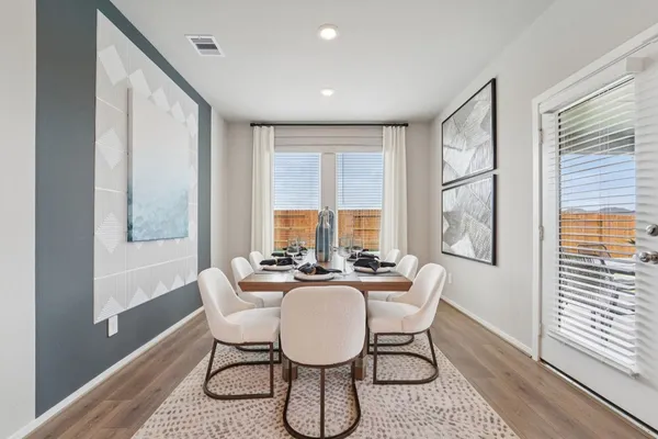 a dining room with furniture a rug and wooden floor