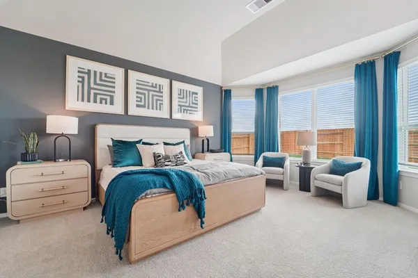 a spacious bedroom with large bed and a couch
