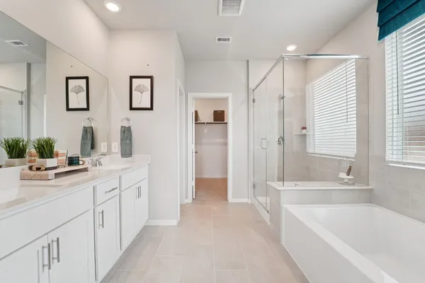 a bathroom with a tub a sink and a large mirror