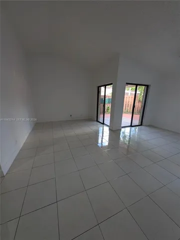 an empty room with windows and fireplace