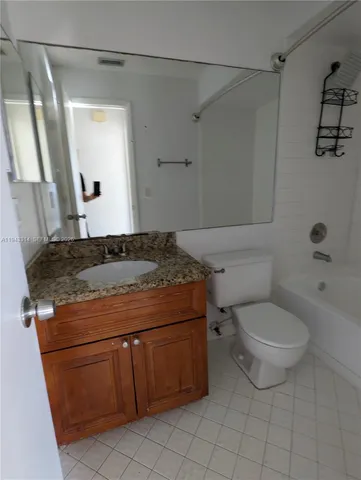 a bathroom with a granite countertop sink a toilet and a mirror