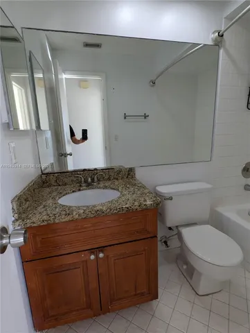 a white toilet sitting next to a bath tub and a shower