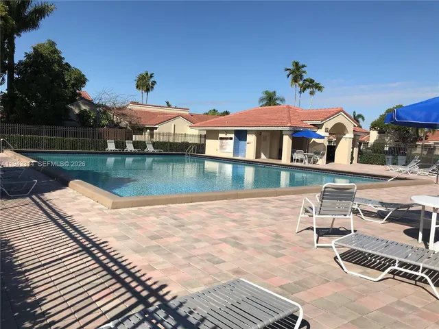 a view of a house with pool and sitting area