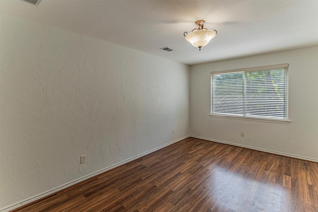 127 Nicklaus Nook Lancaster, TX 75146 - Photo 19 of 37 Empty room with a textured wall and dark wood finished floors