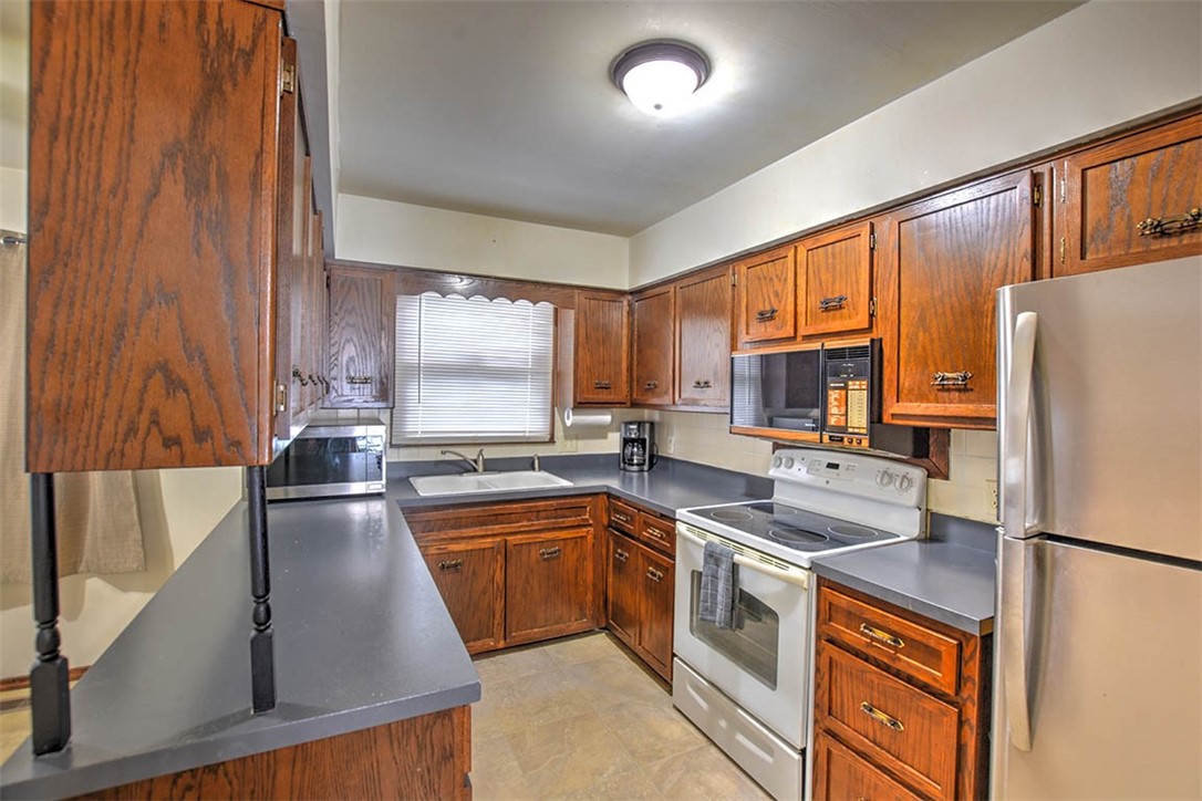 4425 Butler Drive Decatur, IL 62526 - Photo 10 of 22 a kitchen with stainless steel appliances granite countertop a refrigerator a stove a sink dishwasher and white cabinets with wooden floor