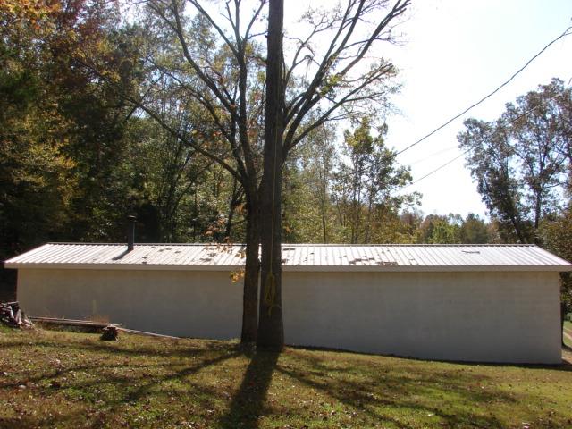 1709 Waverly Road Tennessee Ridge, TN 37178 - Photo 7 of 30 L shaped garage 60 ft long then 40x 20 wide. Can you see the vent for the wood stove. Garage has 2 levels. seller my leave refrigerator in the garage. some shelf units convey some do not. 3 large 6 ft built in cabinets remain