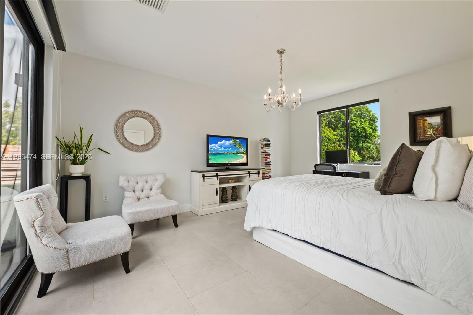 5735 Southwest 35th Street Miami, FL 33155 - Photo 24 of 30 a bedroom with a bed a mirror and a chandelier