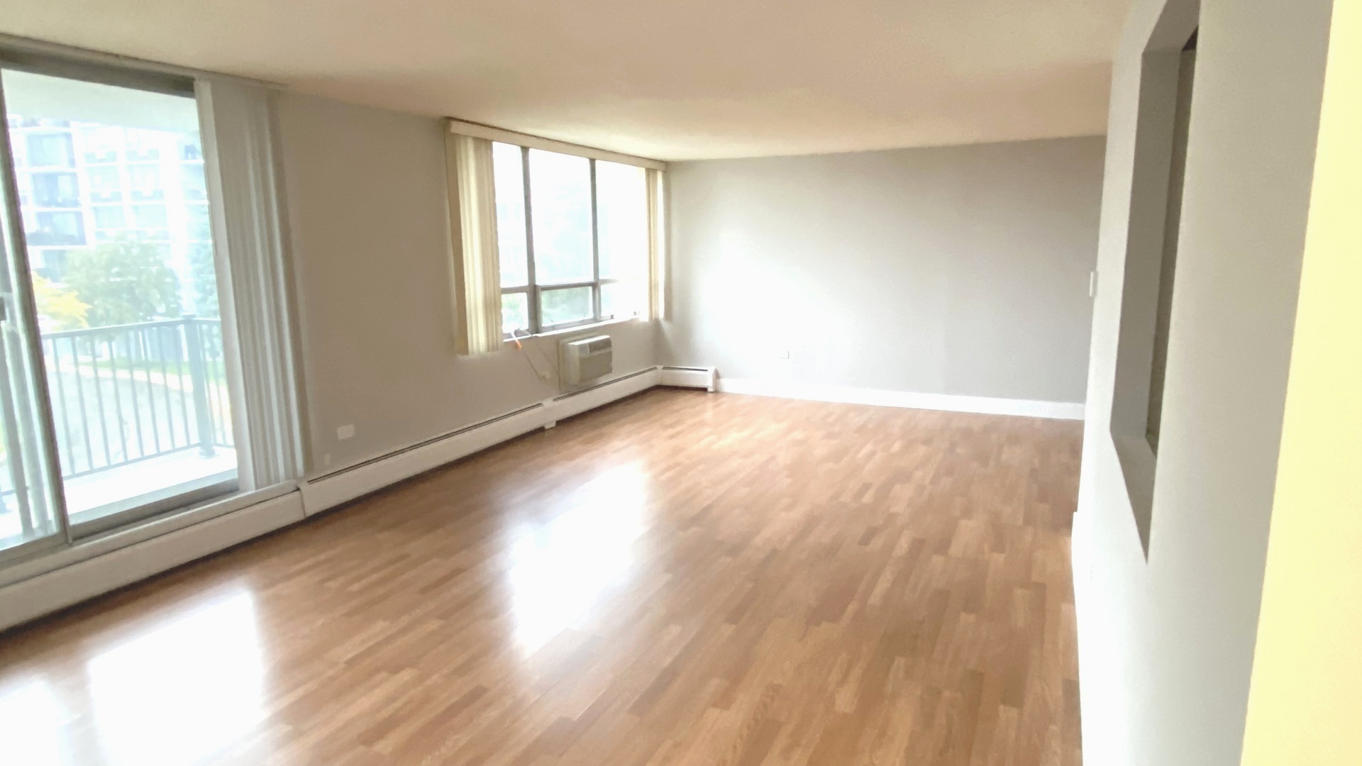 8801 West Golf Road, Unit 3H Niles, IL 60714 - Photo 11 of 33 a view of an empty room with wooden floor and a window