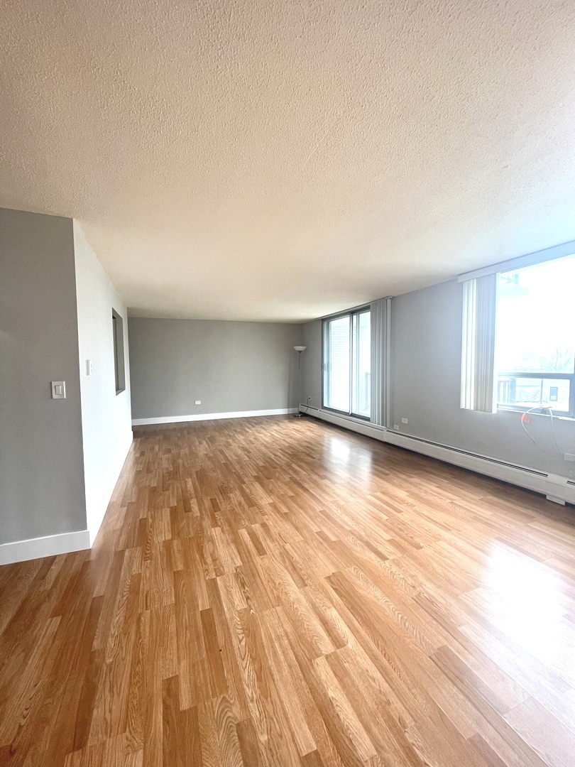 8801 West Golf Road, Unit 3H Niles, IL 60714 - Photo 12 of 33 a view of empty room with wooden floor and fan