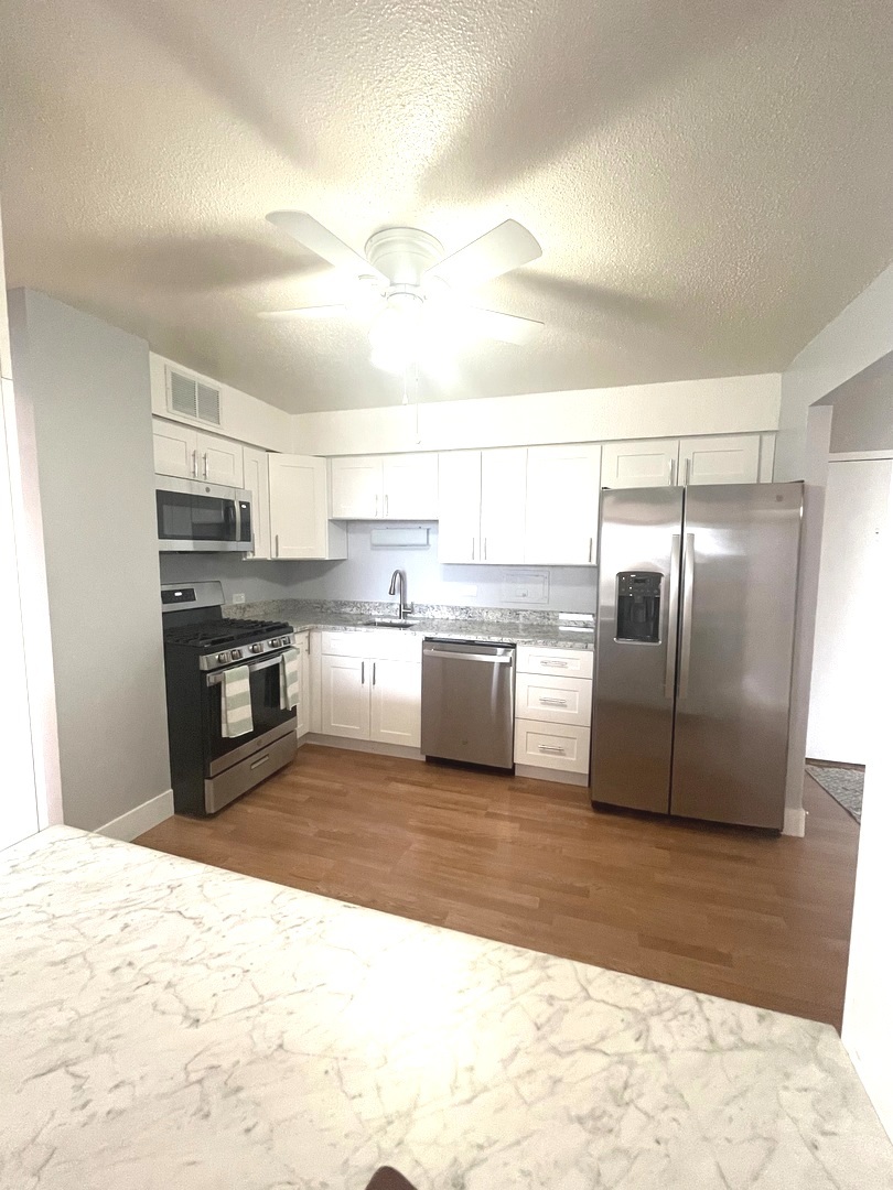 8801 West Golf Road, Unit 3H Niles, IL 60714 - Photo 16 of 33 a kitchen with granite countertop a refrigerator and a stove top oven