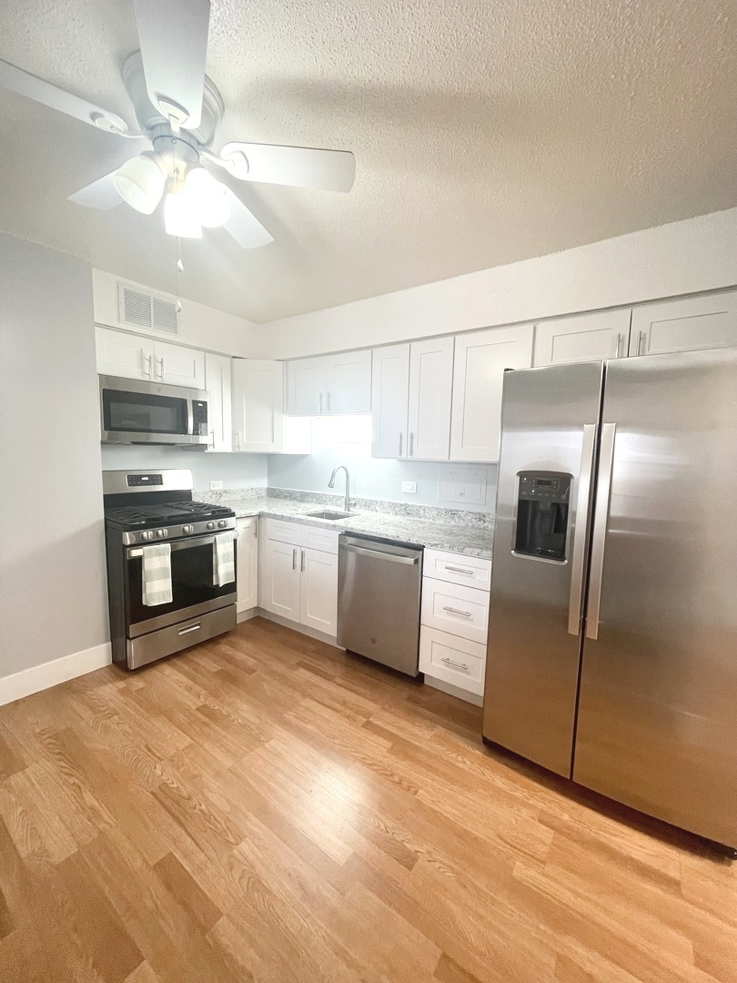 8801 West Golf Road, Unit 3H Niles, IL 60714 - Photo 17 of 33 a large kitchen with cabinets stainless steel appliances and a chandelier