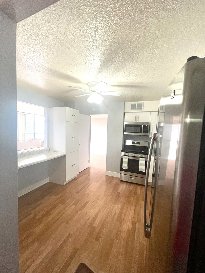 8801 West Golf Road, Unit 3H Niles, IL 60714 - Photo 18 of 33 a view of a kitchen with wooden floor electronic appliances and windows