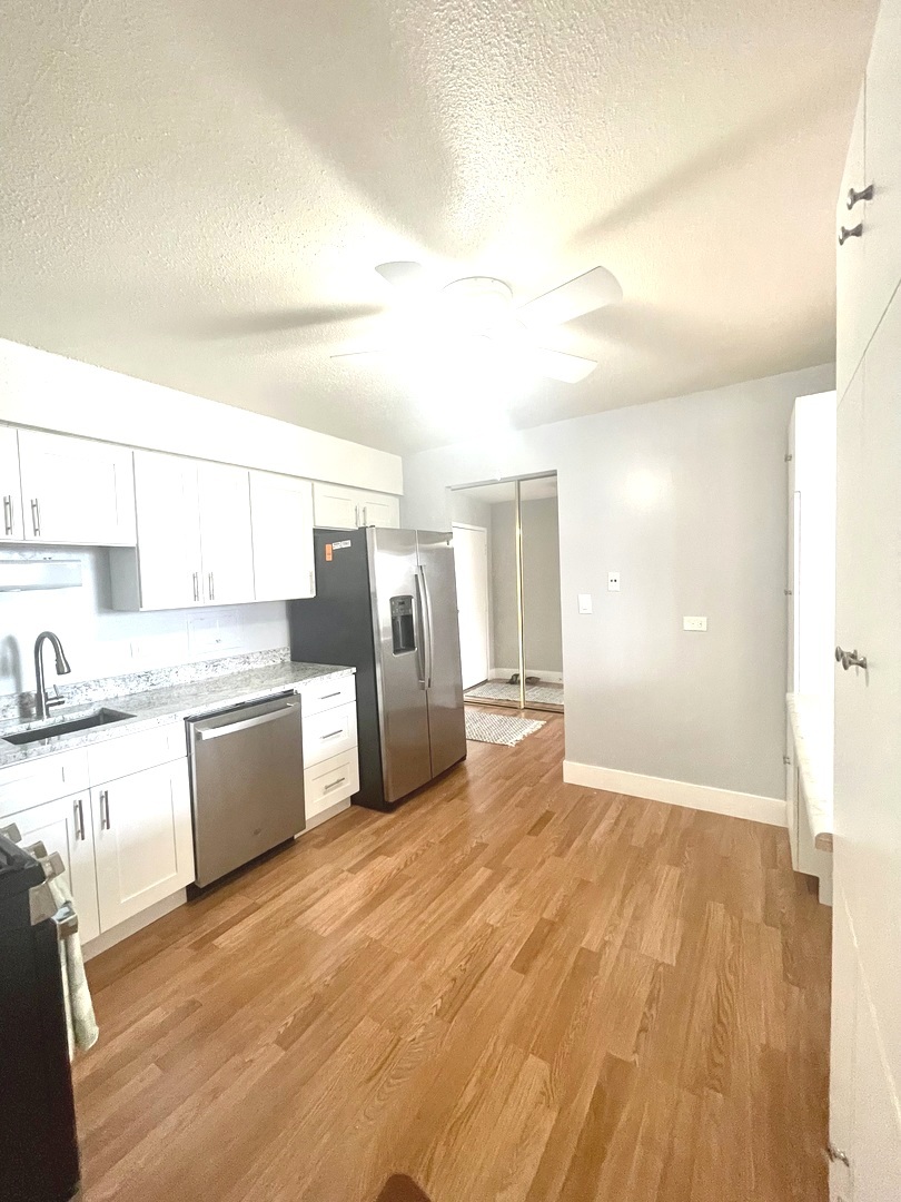 8801 West Golf Road, Unit 3H Niles, IL 60714 - Photo 21 of 33 a large kitchen with cabinets and wooden floor