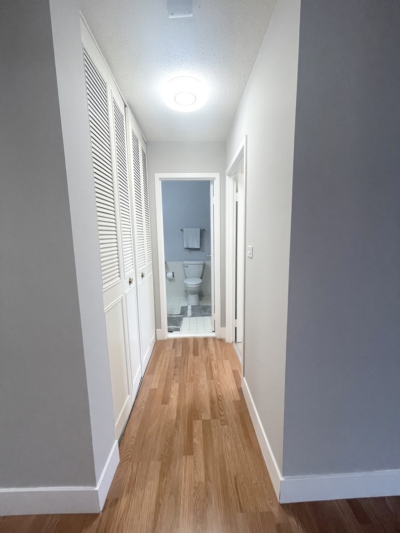 8801 West Golf Road, Unit 3H Niles, IL 60714 - Photo 22 of 33 a view of a hallway with wooden floor and a bathroom