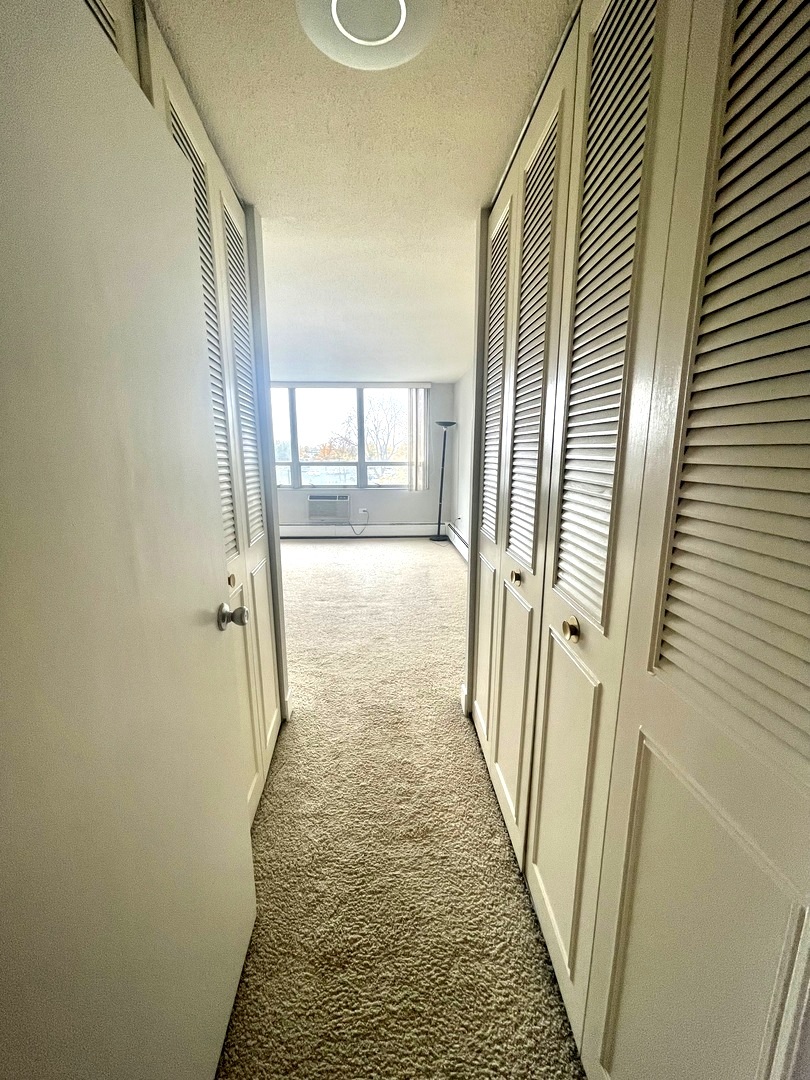 8801 West Golf Road, Unit 3H Niles, IL 60714 - Photo 25 of 33 a view of a hallway with wooden floor and staircase