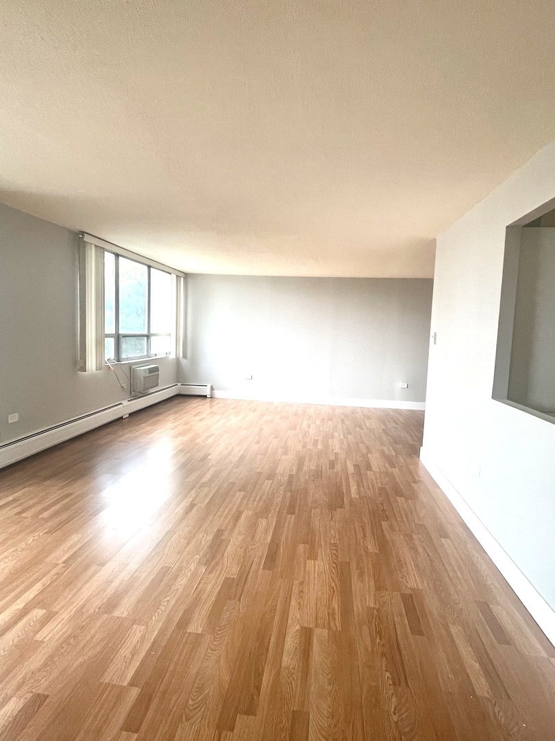 8801 West Golf Road, Unit 3H Niles, IL 60714 - Photo 10 of 33 a view of empty room with wooden floor and fan