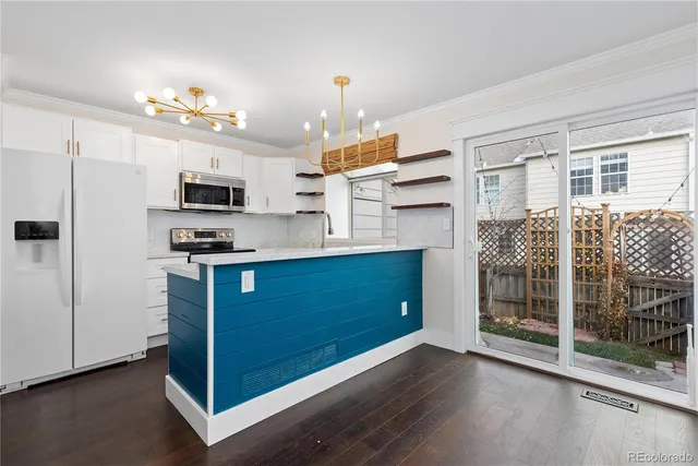 a kitchen with stainless steel appliances granite countertop a sink and a stove top oven with white cabinets